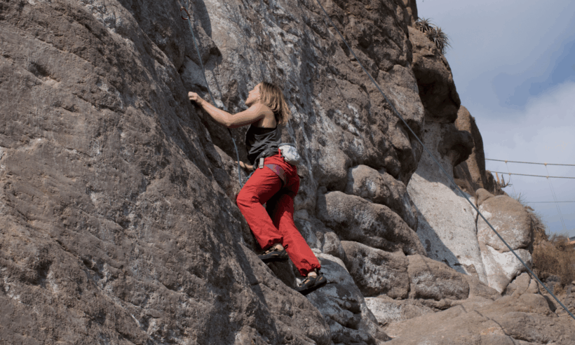mujer escalando roca en valle chilina
