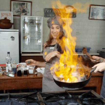 mujer haciendo flameo en clase de cocina peruana