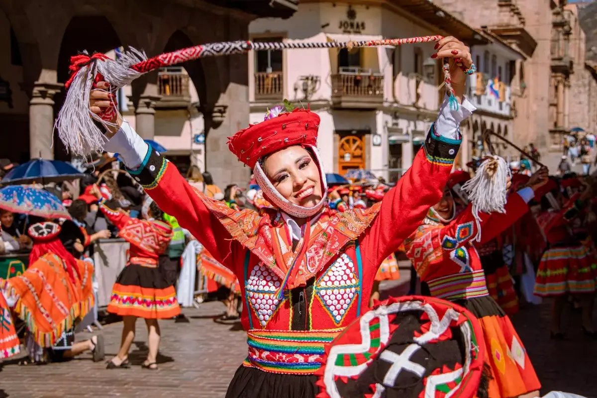 MUJER VESTIDA DE ÑUSTA BAILANDO EN UN PASACALLE EN CUSCO