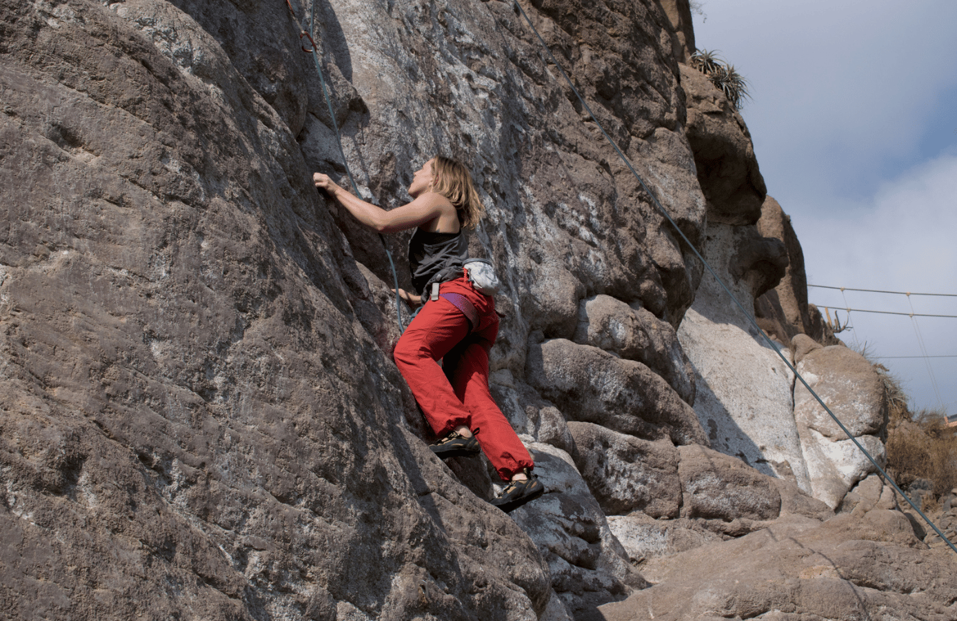 mujer escalando roca